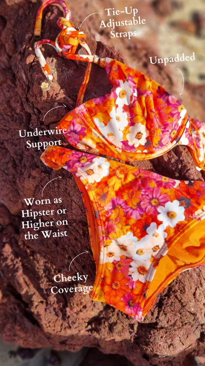 Floral bikini set made in brazil on a brown background by a rocky beach