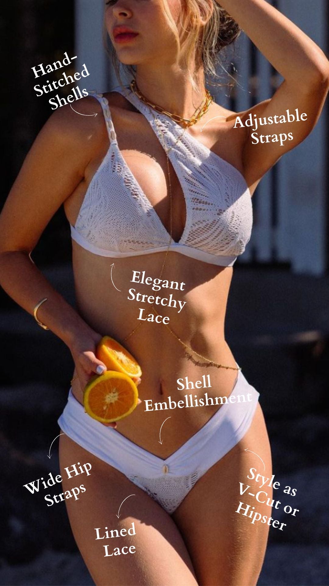 Woman wearing a white bikini with lace and shells features, against a blurred outdoor background.